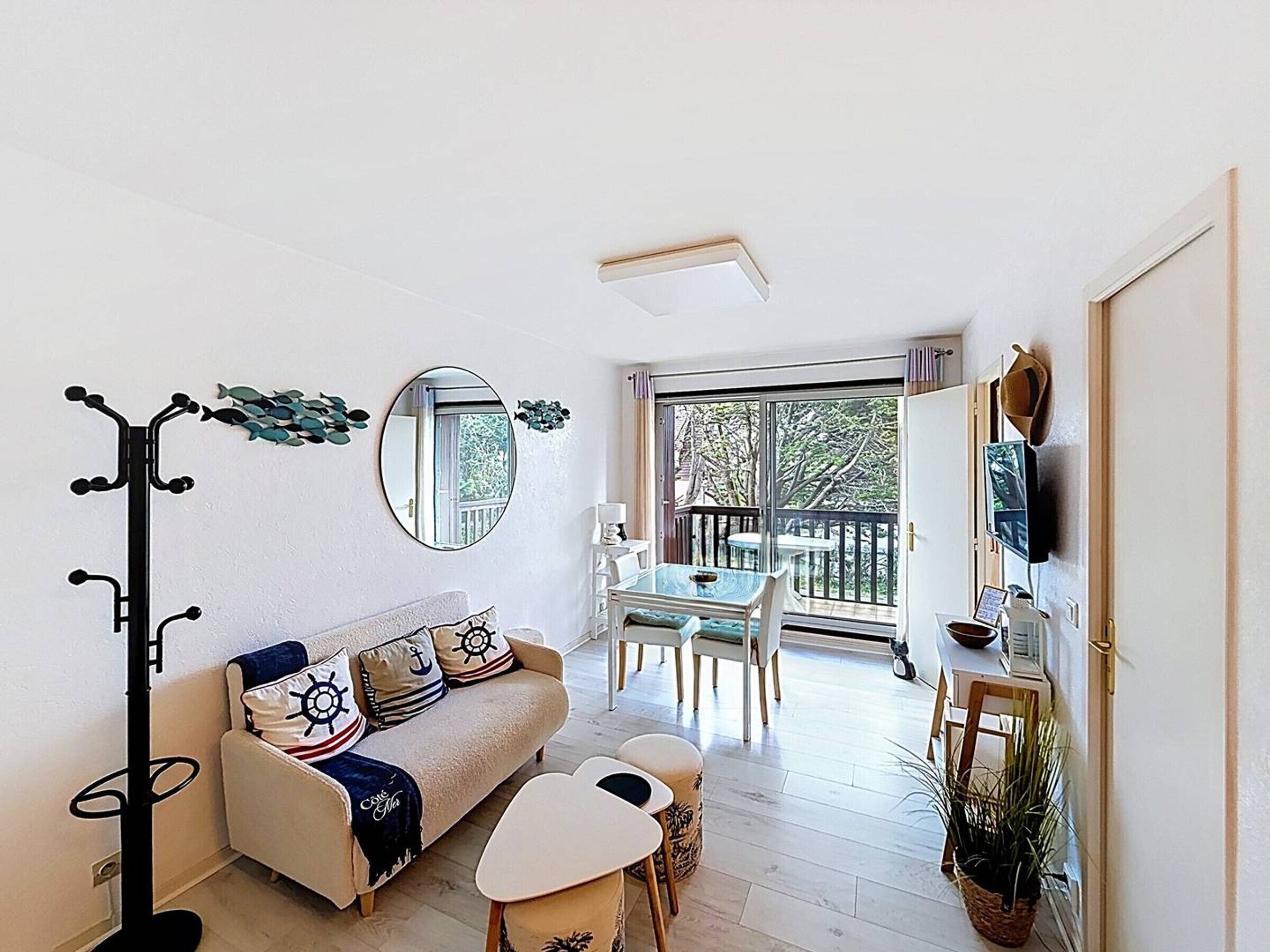 Ein gemütlicher, kleiner Wohnraum mit Sofa, Esstisch und Garderobe.