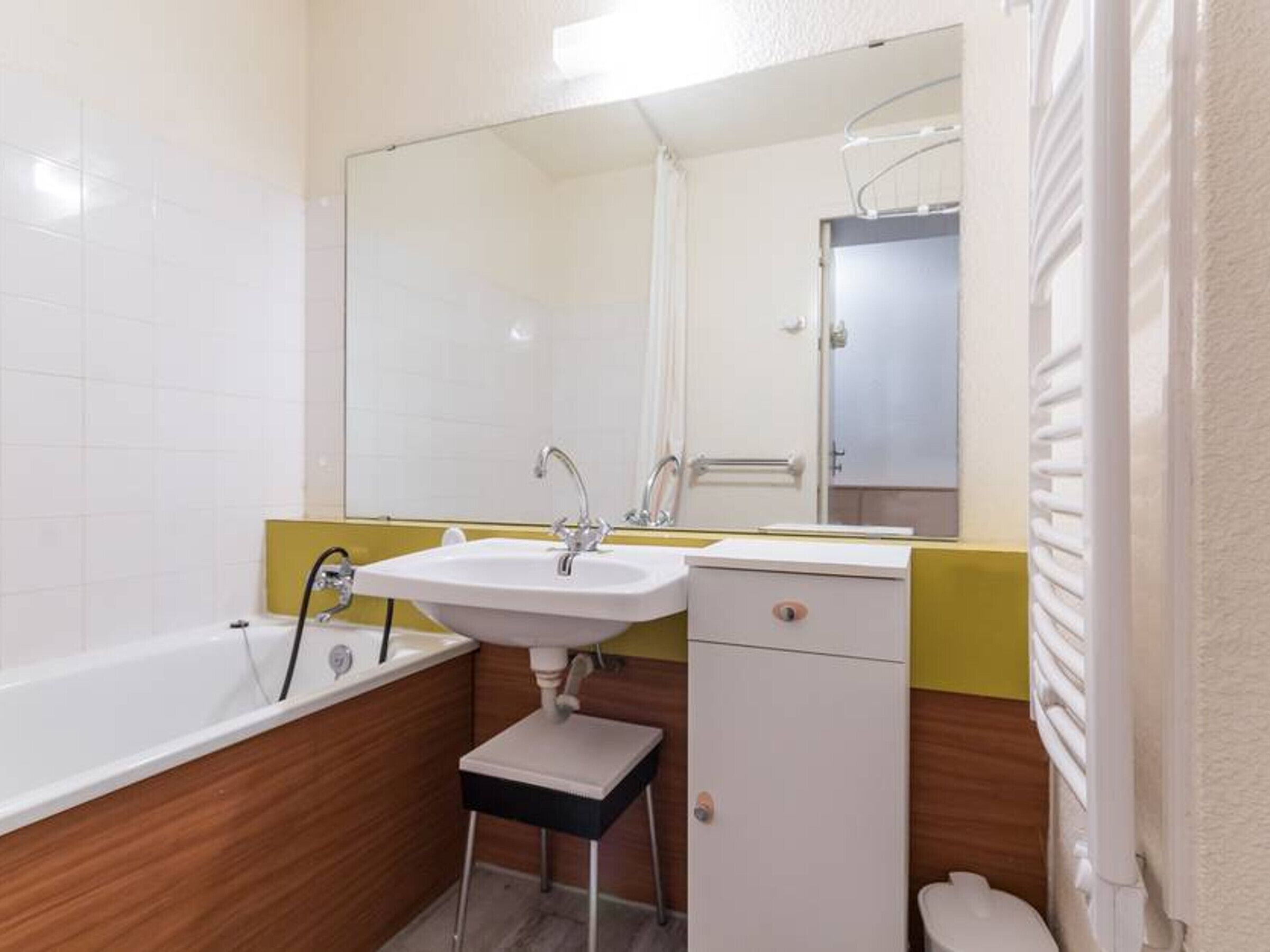 A bathroom with a white sink, mirror, and bathtub.