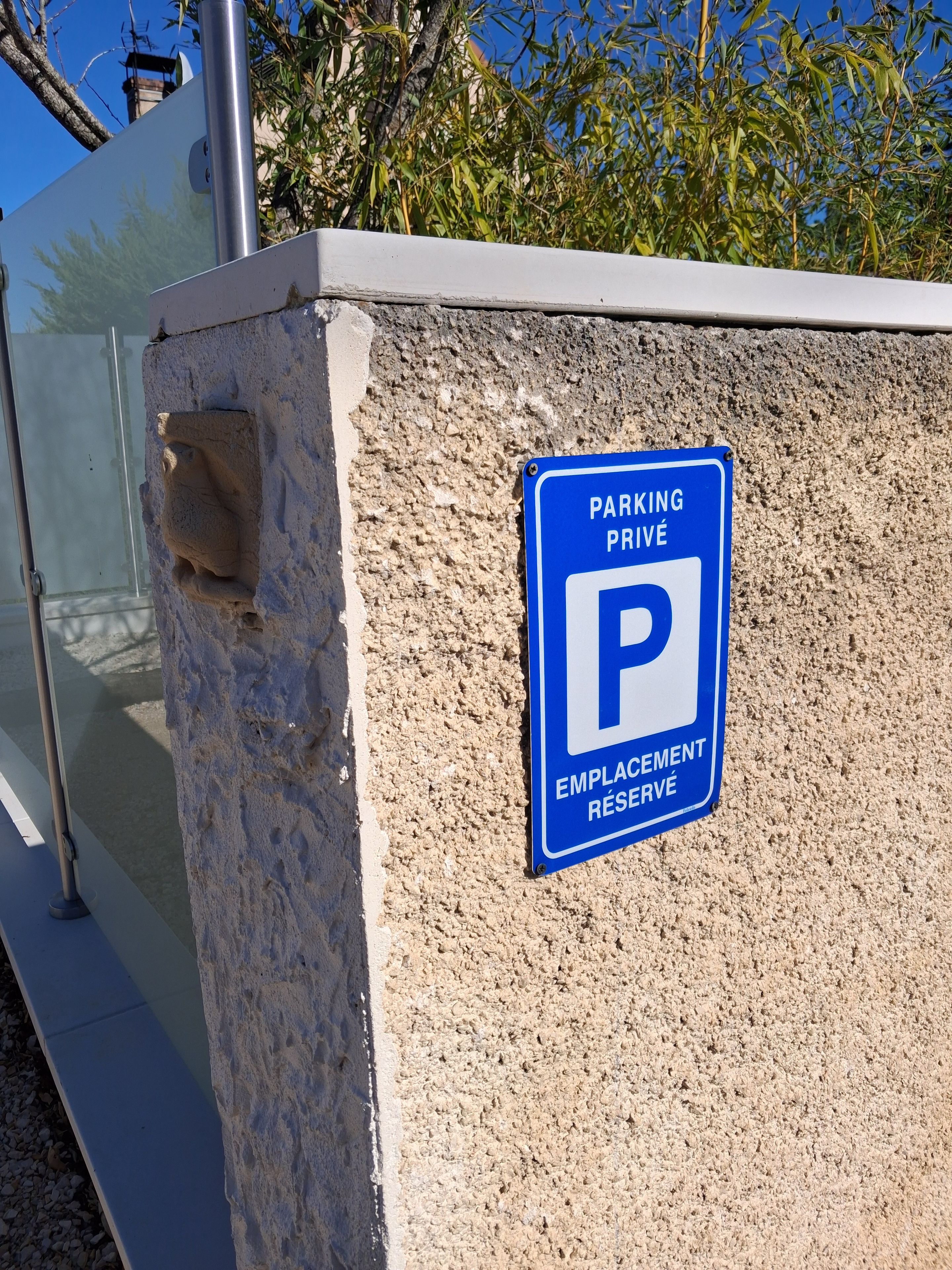 A blue parking sign with a white 'P' on a textured wall.