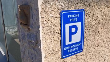 A blue parking sign with a white 'P' on a textured wall.