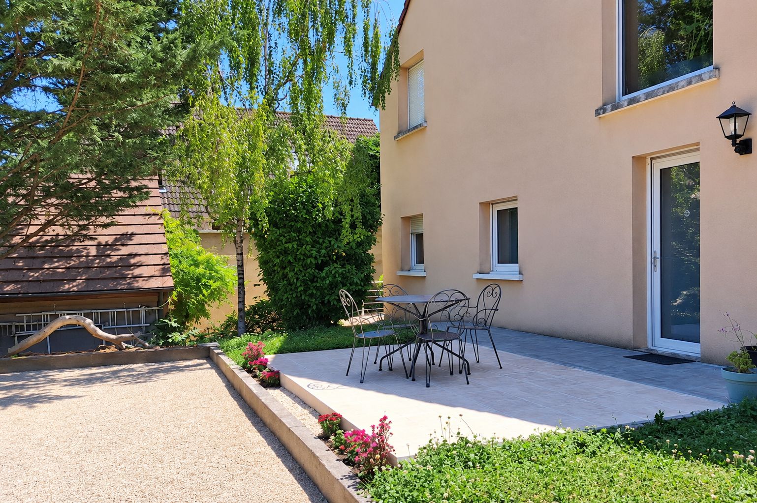 Een woongebouw met een terras, zitplaatsen buiten en een tuin.