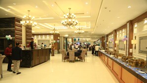A spacious hotel lobby with a long reception desk, multiple chandeliers, and a polished floor. - Hotel Sakura by Maps, GURGAON (Gurugram)