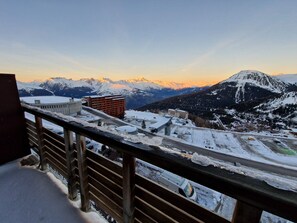 A snowy mountain landscape with a view of a building and a road.