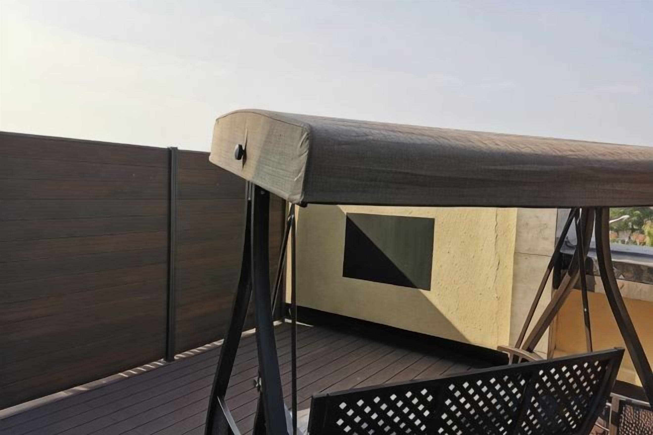 A covered outdoor seating area with a metal frame and a canvas roof.