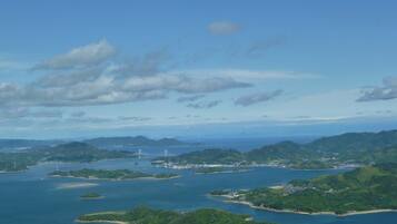 An aerial view of a coastal area with multiple islands, a bridge, and a port.