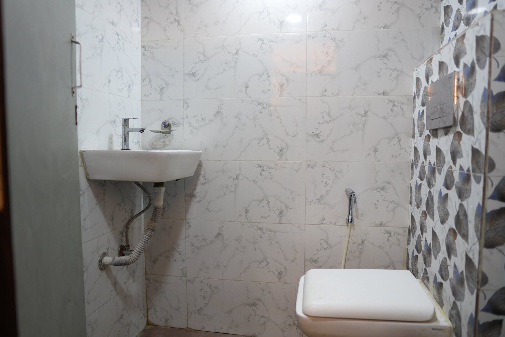 A small bathroom with a white sink, a toilet, and a shower.