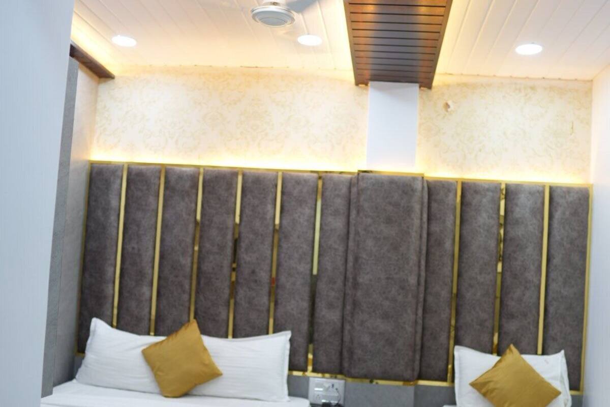 A hotel room with two beds, a modern headboard, and a ceiling fan.