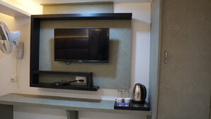 Een moderne kitchenette met een ingebouwde televisie, een koffiezetapparaat en een ventilator.