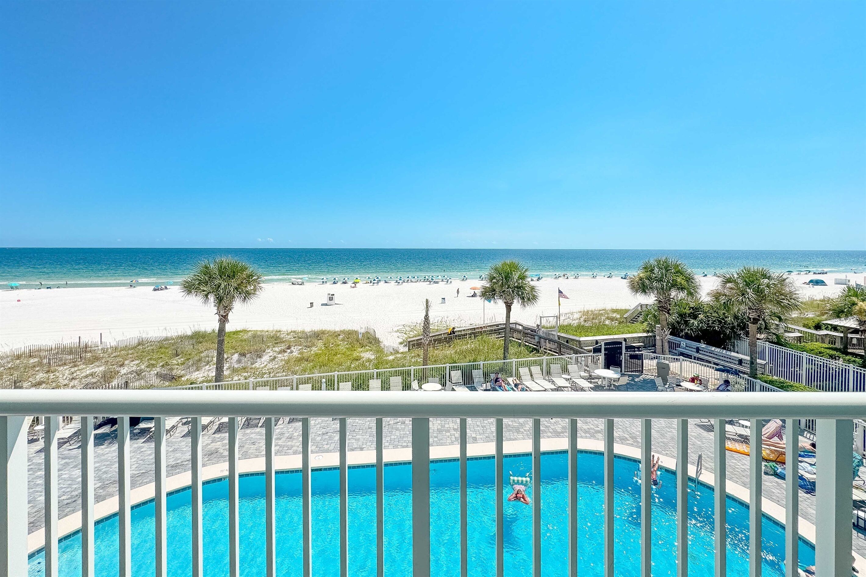 A pool with a view of the beach and ocean.