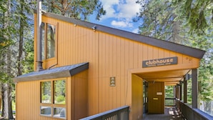 A wooden cabin with a sign reading "Clubhouse rentals, sauna, pool".
