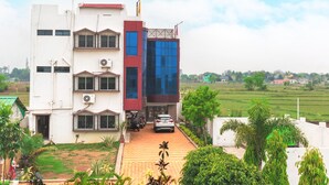 Un immeuble à plusieurs étages, doté d’une architecture moderne, avec une façade aux couleurs contrastées, mêlant le blanc et le rouge, et une voiture garée devant.