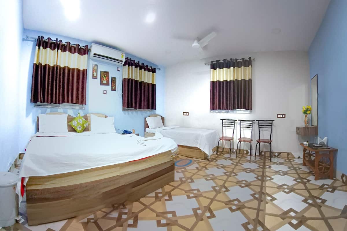 A hotel room with two beds, a desk, and a chair.