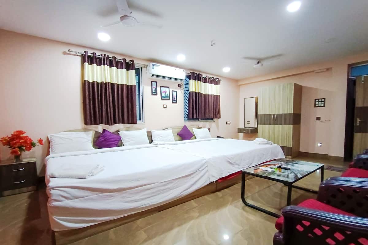 A hotel room with a large bed, a glass coffee table, a desk, and a wardrobe.