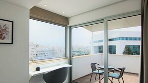 A balcony with a view of the city, a chair, and a small table. - Phaedrus Living Luxury Suite Nicosia 507 (Strovolos)