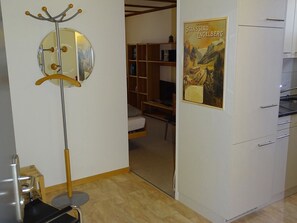 Una habitación con una cama, un armario, un espejo y un cartel en la pared.