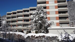 A multi-story building with a modern architectural style, featuring a mix of brick and white exterior walls, and balconies on each floor. - Parkweg 9/602 Appartement/Fewo 2-Bettwohnung by Interhome (Engelberg)