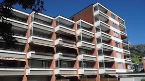 A multi-story residential building with balconies, brick facade, and a clear sky. - Parkweg 9/602 Appartement/Fewo 2-Bettwohnung by Interhome (Engelberg)