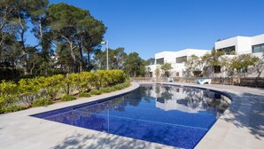 A swimming pool with a tiled edge, surrounded by a landscaped area with trees and shrubs. - 4 Bedroom Modern House, Llafranc, Costa Brava (Llafranc)