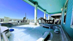 A hot tub area with a view of the ocean and a building in the background. - Sweet & Salty - Hot Tub, Across from Jetty, Best Ship Watching! (Surfside Beach)
