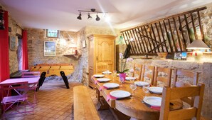 A rustic dining area with a wooden table set for four, stone walls, and a wooden bench. - Holiday Accommodation "Maison de pierre" with beautiful view (Saint-Gervais)