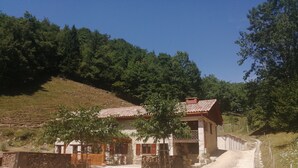A rustic building with a stone facade, a red-tiled roof, and a gravel driveway. - Holiday Accommodation "Maison de pierre" with beautiful view (Saint-Gervais)
