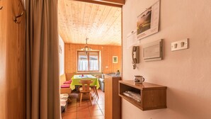 Een houten interieur met een eethoek, een keuken en een klein plankje met een waterkoker.