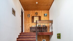 A wooden staircase with a metal handrail, a wooden door, and a small picture on the wall.