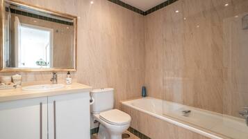 A bathroom with a sink, toilet, and bathtub.