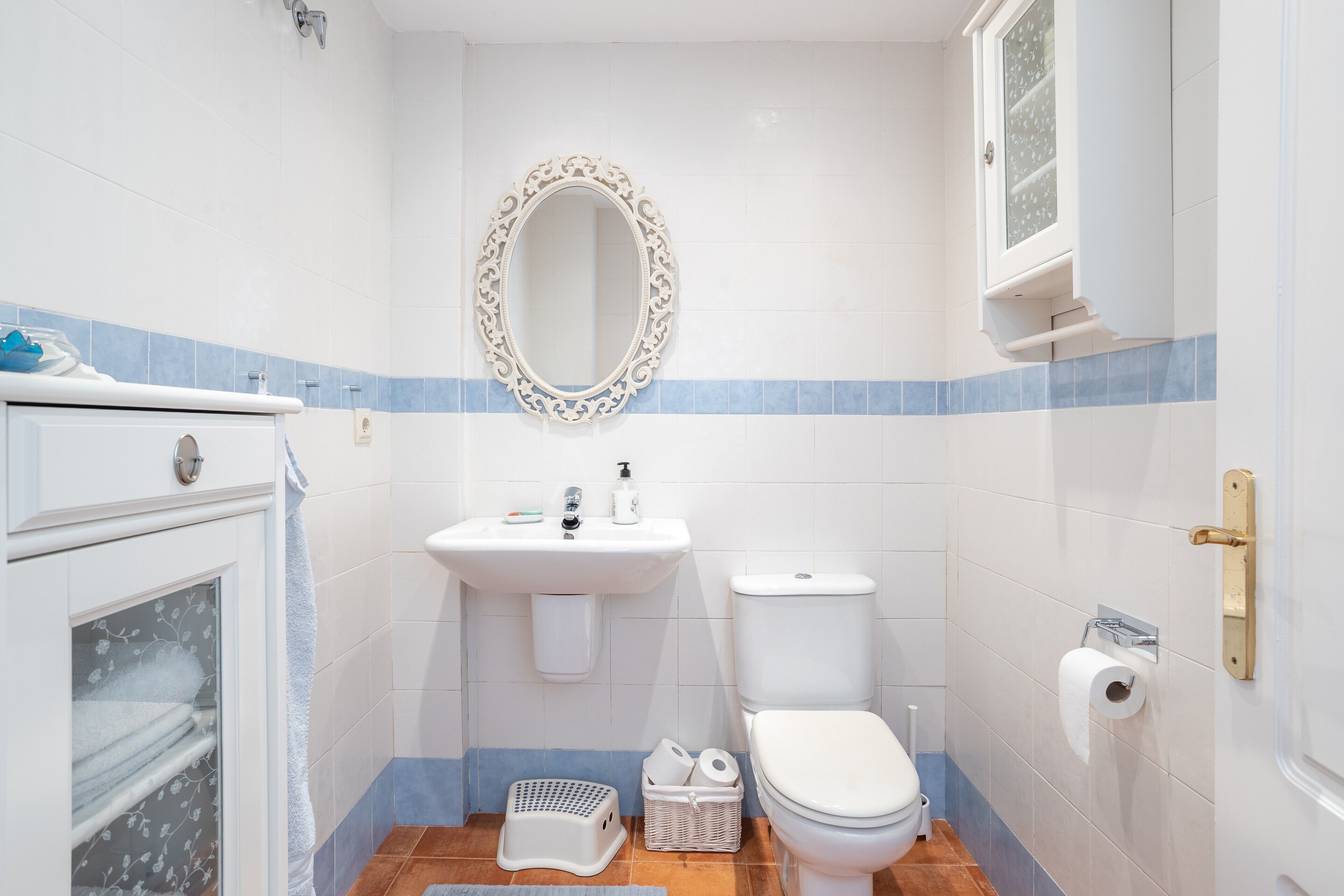 Un baño con inodoro, lavamanos, espejo y ventana.