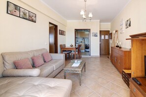 A living room with a sofa, coffee table, and wooden cabinet.
