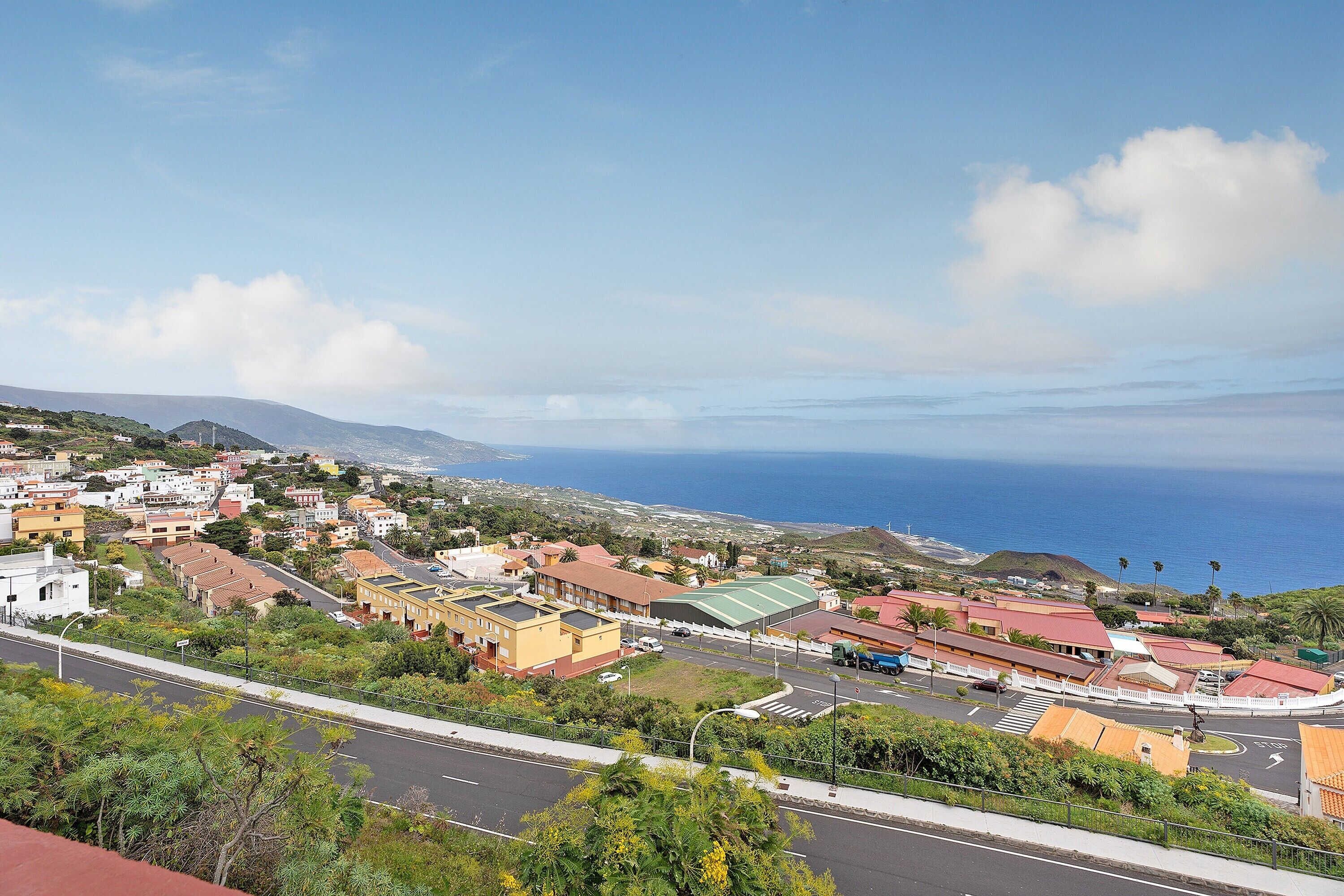Une ville côtière avec des bâtiments, une route et une vue sur la mer.