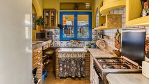 A compact kitchen with a sink, stove, and various utensils. - Holiday Home "Casa en urb Cala Montgó" with Private Terrace and Wi-Fi (L'Escala)