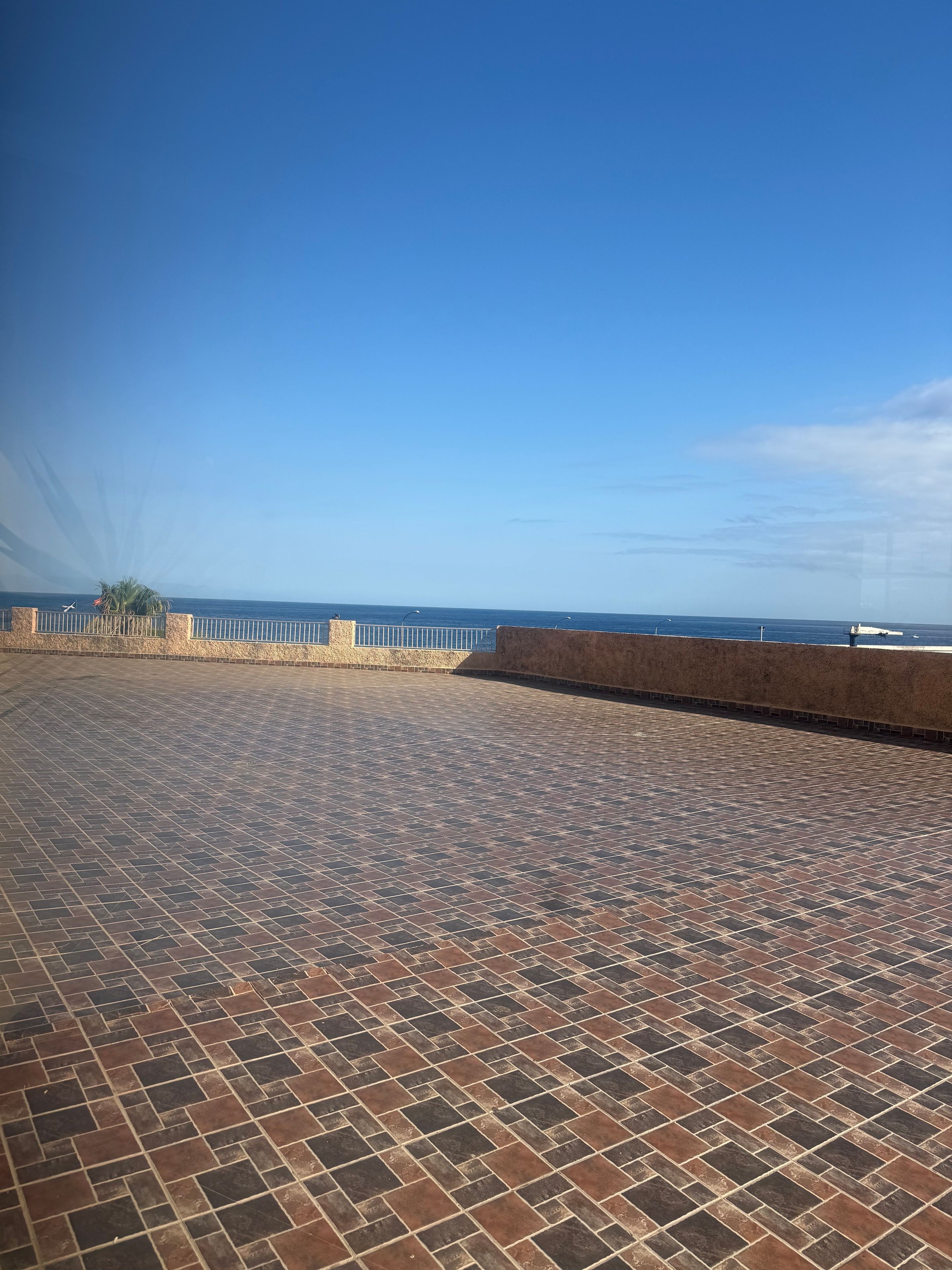 Een betegeld terras met uitzicht op zee.