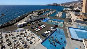 A coastal marina with boats, a swimming pool, and a parking area. - Holiday Home 'Sea view Apartment' with Sea View, Shared Pool & Wi-Fi (Candelaria)