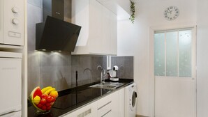 A modern kitchen with a dishwasher, a sink, and a fruit bowl.