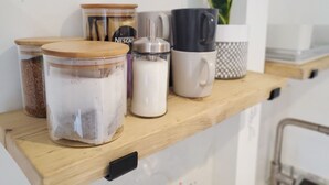 A wooden shelf with various kitchen items including jars, a coffee maker, and a mug. - Saltdean annexe, excellent location (Saltdean)