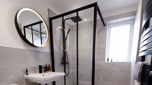 A modern bathroom with a toilet, sink, shower enclosure, and a mirror. - Saltdean annexe, excellent location (Saltdean)