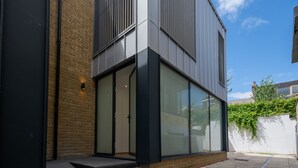 Un bâtiment moderne doté de grandes fenêtres, d’une façade en briques et d’un toit plat.