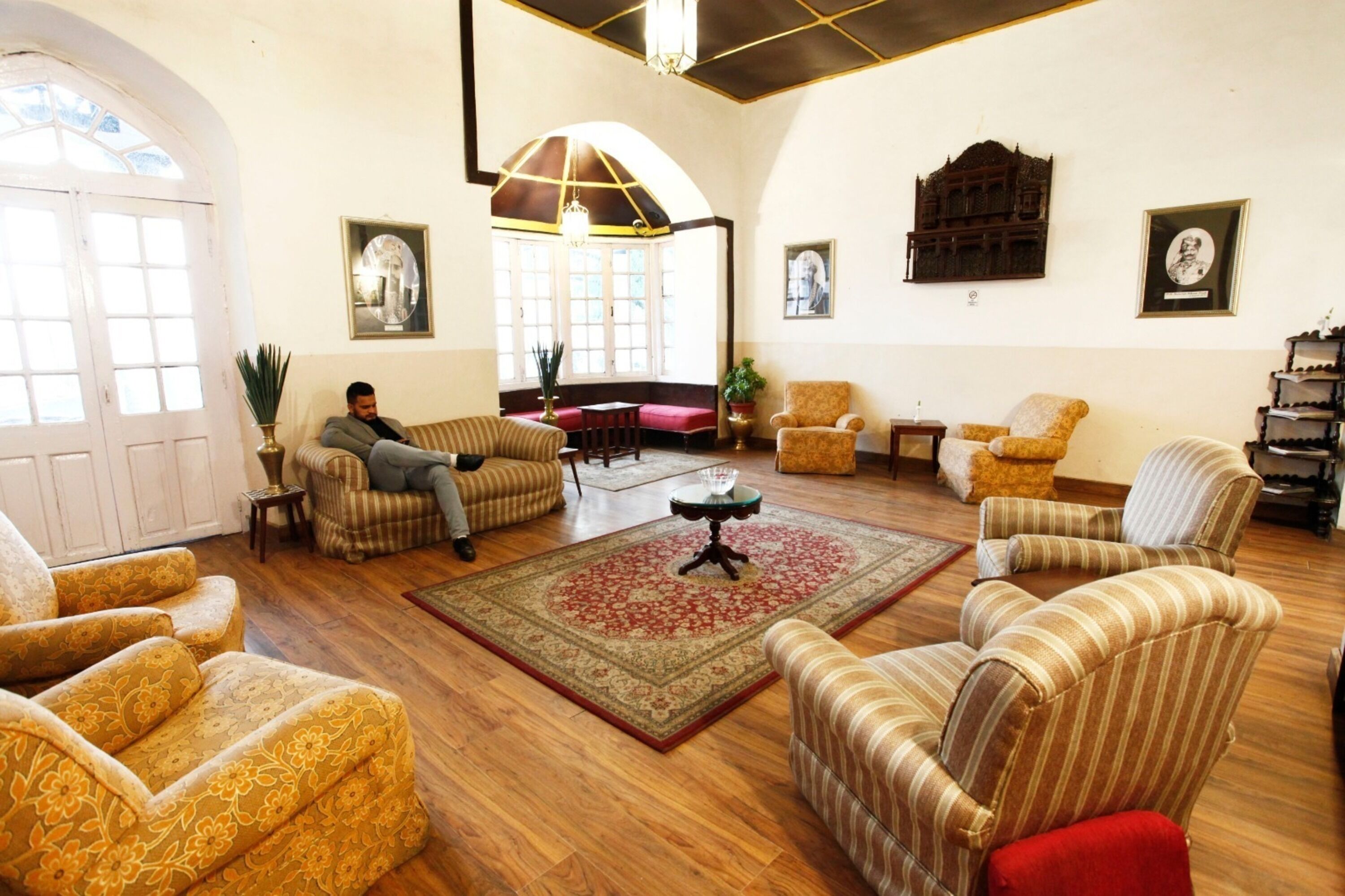 A spacious living room with multiple sofas, a coffee table, and a large window.