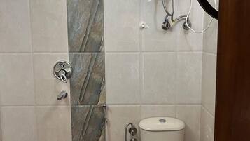Un baño con ducha, inodoro y calentador de agua.