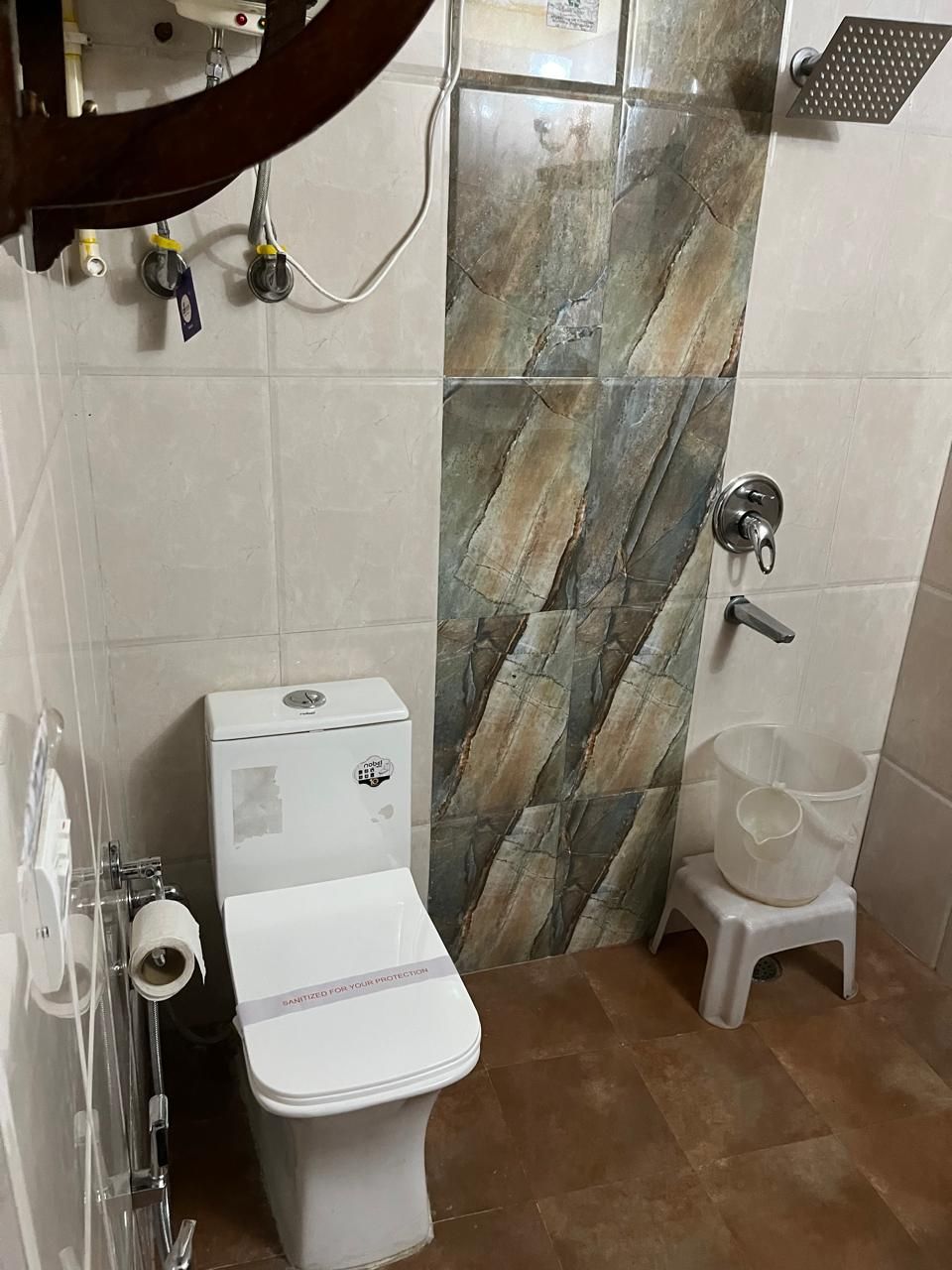 A small bathroom with a toilet, a sink, and a shower.