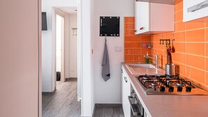 Une cuisine moderne avec des meubles blancs, une cuisinière à gaz et un four.