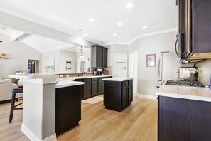Enjoy cooking in this well-lit kitchen with a sink, ample counter space, and dark cabinetry.