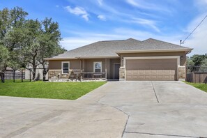 A single-story house with a garage, a front lawn, and a tree.