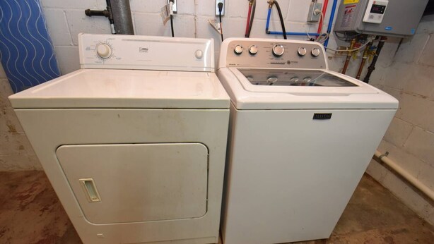 A white washing machine and dryer side by side in a room with a concrete floor and a blue wall. - 20 min Walk to ND, 3 bedroom 2 bath home(54475) (South Bend)