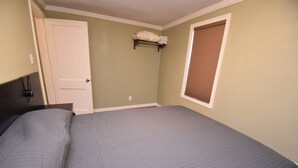 A bedroom with a bed, a door, a window with blinds, and a shelf with folded towels. - 20 min Walk to ND, 3 bedroom 2 bath home(54475) (South Bend)