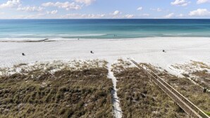 Una spiaggia con un litorale sabbioso e una passerella in legno che conduce verso l'acqua.