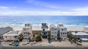 Una proprietà fronte spiaggia con diversi edifici, un’area di parcheggio e vista sull'oceano.