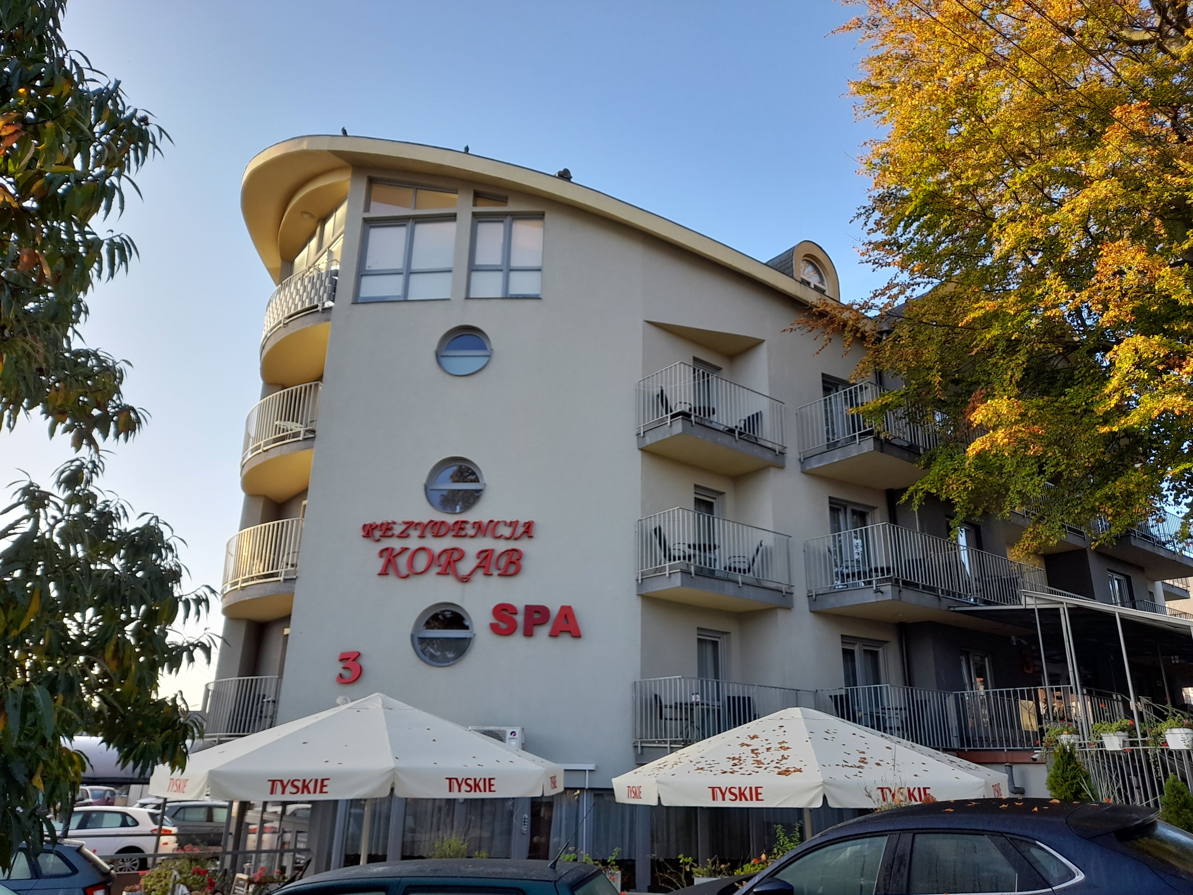 En byggnad med balkonger och en skylt med texten ”REZIDENCJA KORAB SPA”.