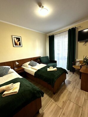 Two single beds with matching bedding and a flat-screen TV.